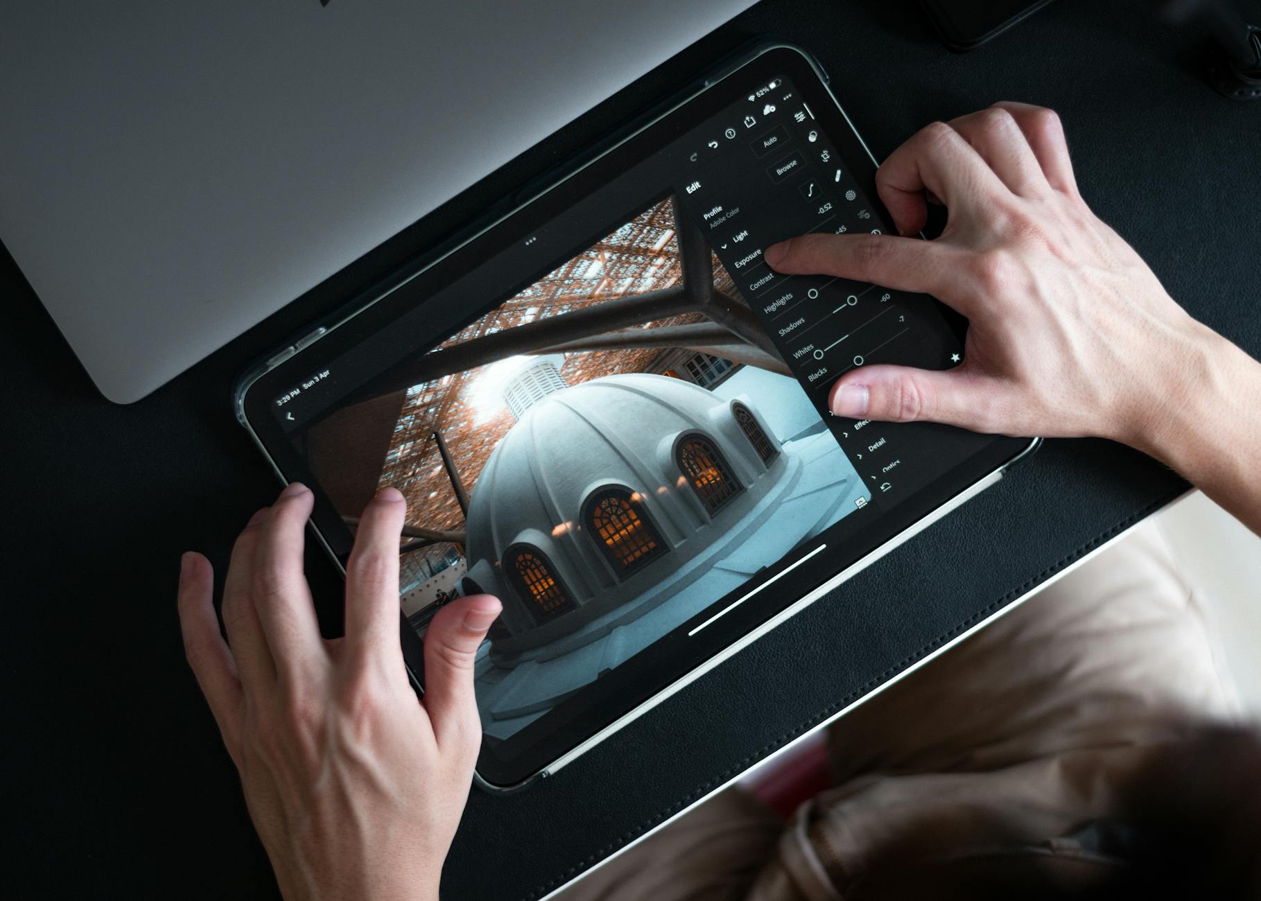 Dłonie edytujące zdjęcie łazienki na tablecie w Lightroom