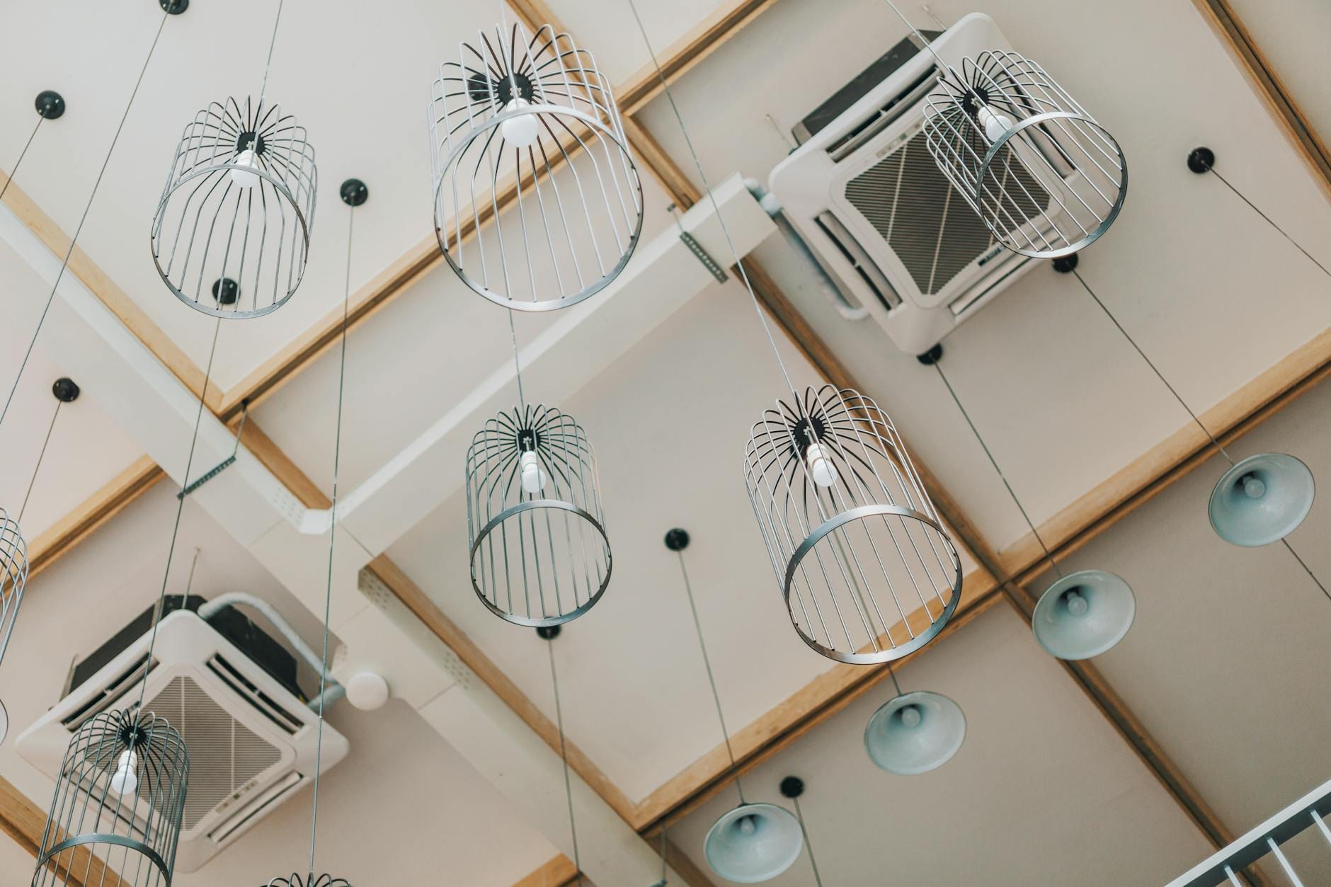 Nowoczesne lampy wiszące na tle designerskiego sufitu w salonie