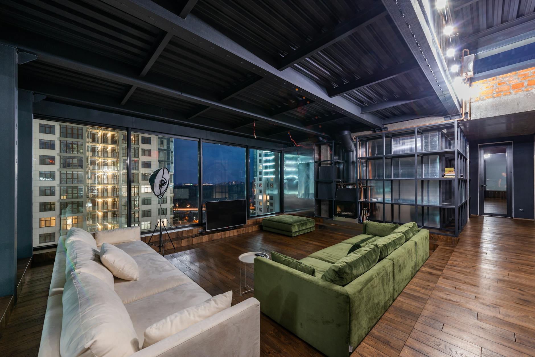 Nowoczesny loftowy salon z dużymi oknami i industrialną lampą