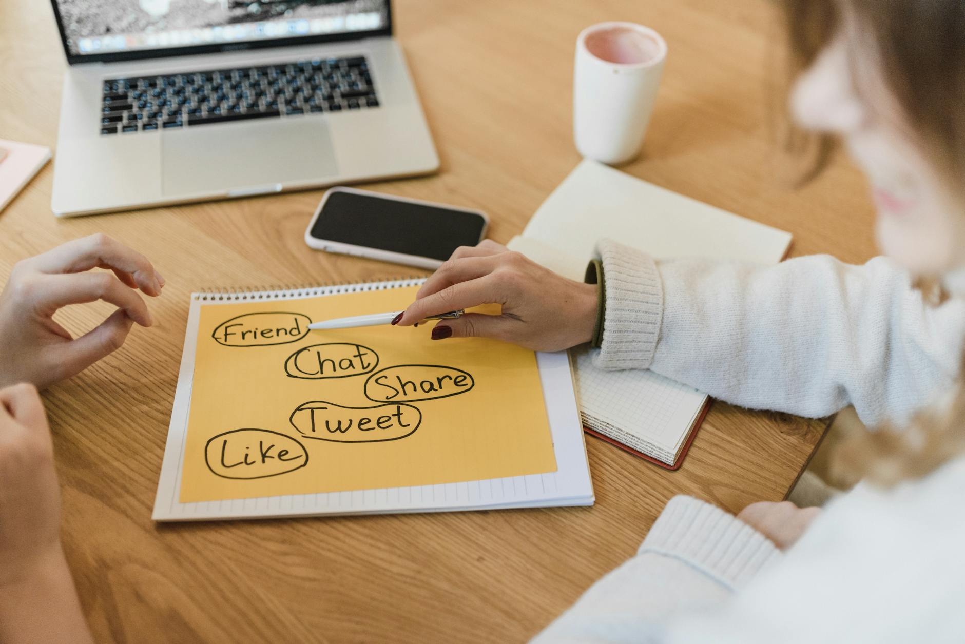 Dwie kobiety planujące kampanię Google Ads przy laptopie i smartfonie