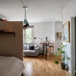 Przytulny nowoczesny salon w kawalerce z roślinami i wygodnym fotelem