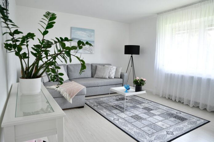 Jasny skandynawski salon z szarą sofą i